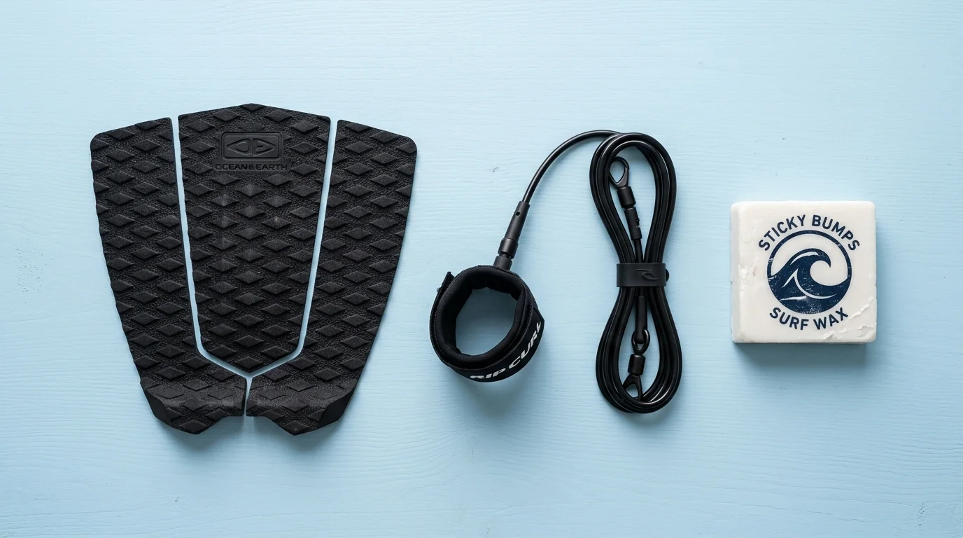 Surfboard tail pad, leash, and wax on wet wood deck